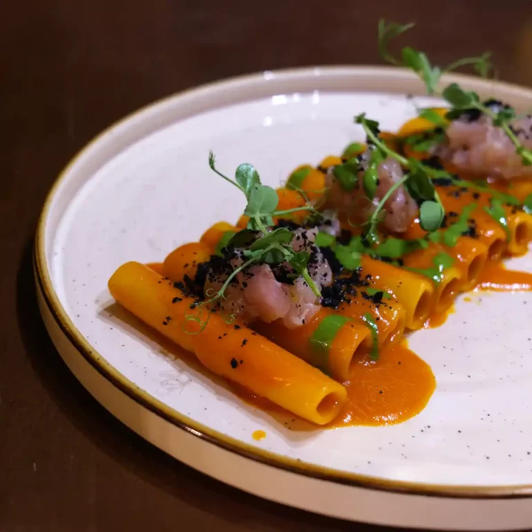 Piatto di candela con estratto di peperoni arrosto, pesto di basilico e tartare di ricciola